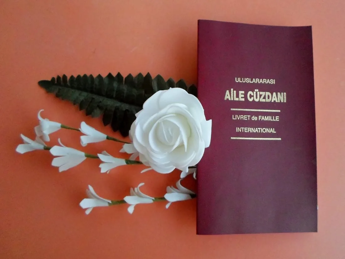 Aile Cüzdanı — Turkey's official International Family Book, presented with white wedding flowers